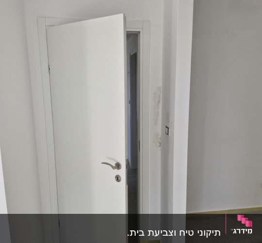 קיר צבוע עם סימני תיקון צבע ליד דלת